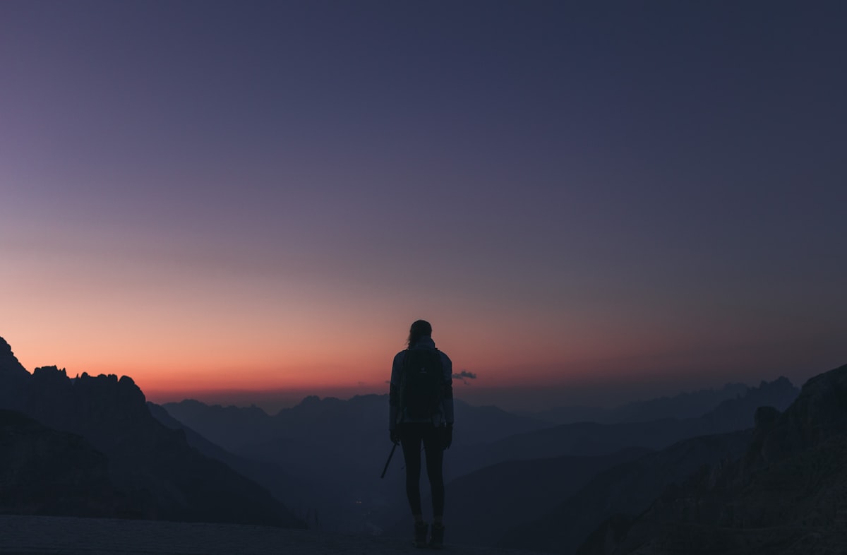 Person on a mountain at sunset — reconnecting with the natural electromagnetic environment